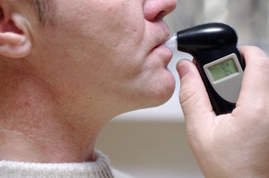 A man blowing into a police breath testing machine