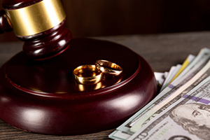 Wedding rings and money on a wooden table