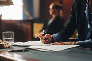 Woman in suit writing in courtroom